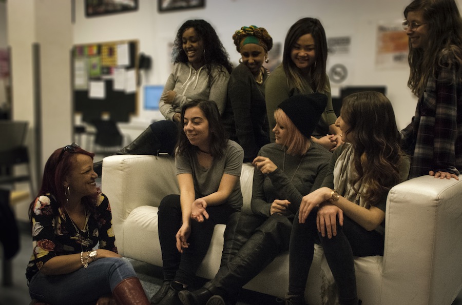 Diverse group of young women together sat together and sharing a moment of conversation.