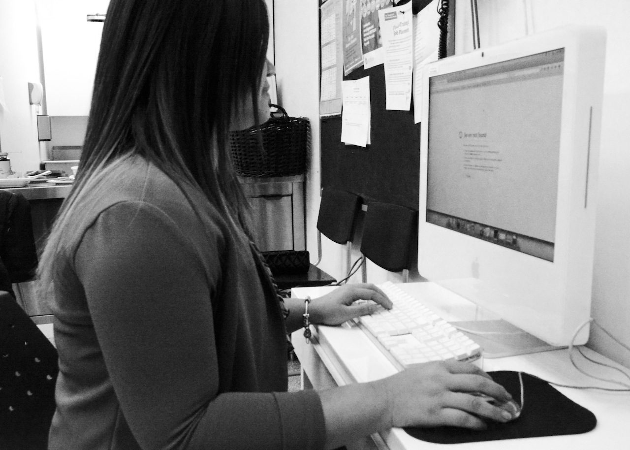 Profile of young woman staring at computer screen.